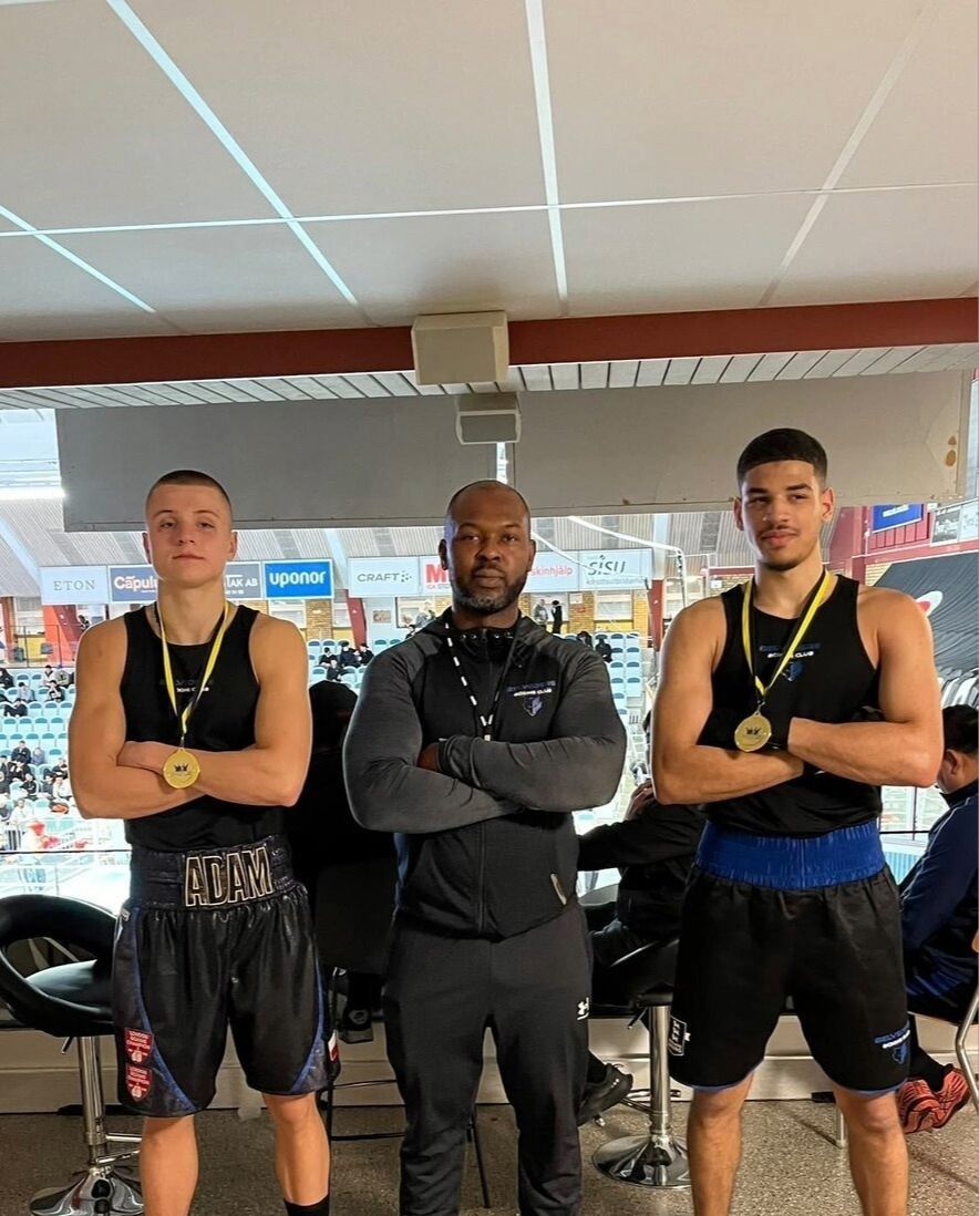 Adam and a clubmate with gold medals and their coach